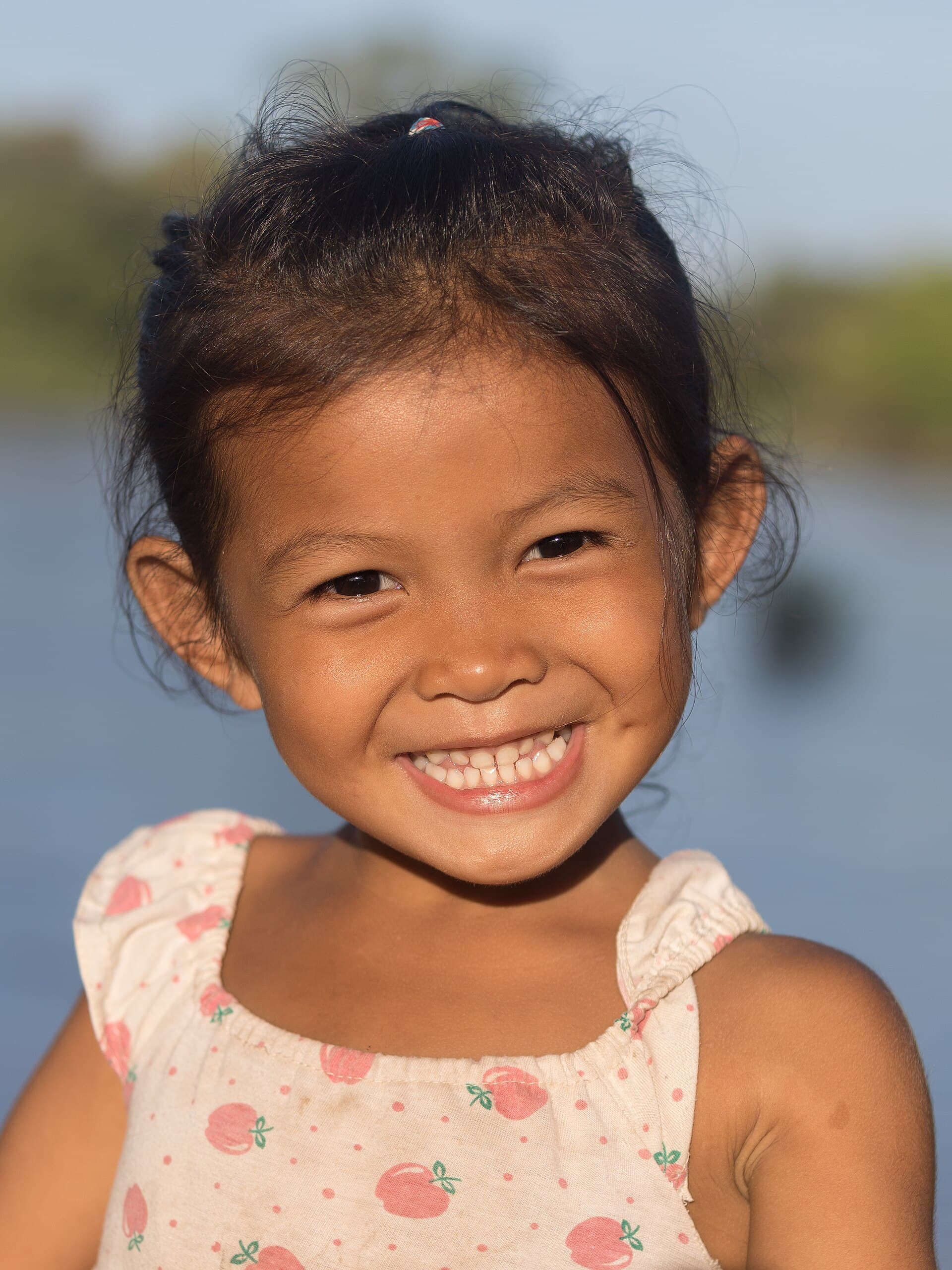 A young girl smiling in sunshine